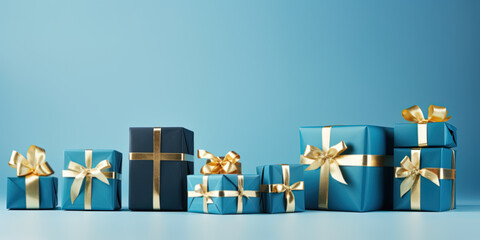 Blue Christmas gift boxes with golden bows on blue background with copyspace - obrazy, fototapety, plakaty