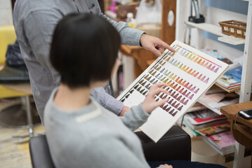 美容院でヘアカラーのカラーチャートを見る女性
