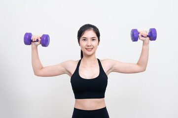 Fototapeta na wymiar Asian woman wearing black workout clothes with smiling face Exercising with purple dumbbells with cheerfulness against a white background or isolated
