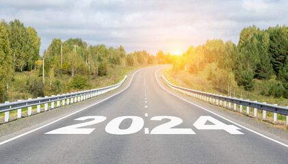 2024 written on highway road in the middle of empty asphalt road and beautiful blue sky. Concept for vision new year 2024. 