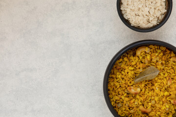 Raw poha (in small bowl) and kanda poha - indian breakfast dish made of flattened rice.