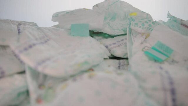 Scattered baby diapers on a table on a white background. The concept of hygiene and protection against leakage in children. Cotton comfort diapers. Moisture indicator