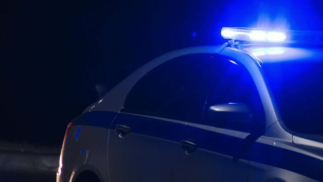 Flickering blue light flasher lightbar on police car at night street, siren. Emergency vehicle lighting on highway patrol auto during traffic collision accident or crime scene. Roads traffic authority