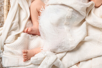 Newborn baby lying on white blanket, closeup