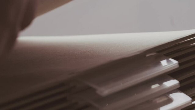 close-up female hands sort through cardboard folders, archive documents, file cabinet HR department, family tree, organize financial documents, organization's activities, finances, projects, events