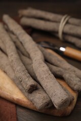 Raw salsify roots on wooden table, closeup