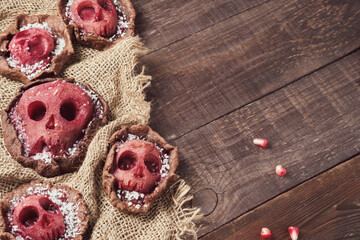 Halloween food. Homemade tartlets with jam and scary skull-shaped pears. Grim Reaper Halloween...