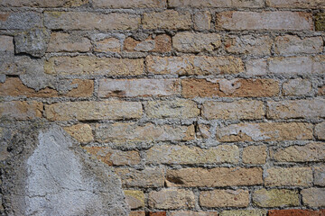 Detail of an old brick wall with peeling plaster.