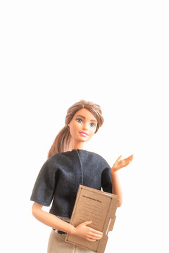 ファイルを持って片手でジェスチャーしているバービー人形 - プレゼンや説明する女性のイメージ素材 - 2:3比率	
