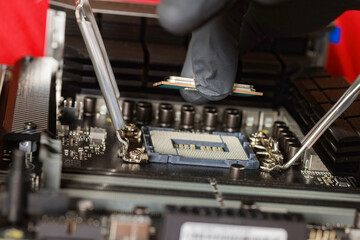 Technician assembling desktop computer with plug in CPU to motherboard socket