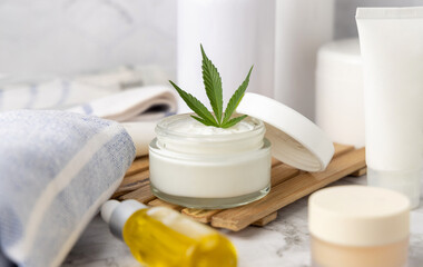 Fototapeta na wymiar Opened cream jar with green cannabis leaves close up, organic natural CBD cosmetic