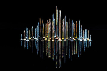 Fantastic city of screws, bolts and nuts with a reflection on a black background. The idea of an advertising photo of a fastener