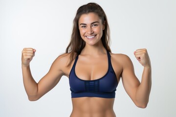 Fototapeta na wymiar Portrait of a smiling sportswoman in deep blue color sportswear showing her biceps isolated on a white background and Looking at the camera.