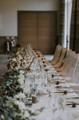 Top table of a wedding reception  decorated in white, green and cream 