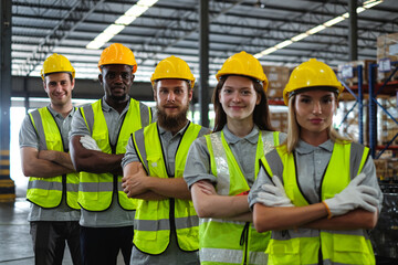 Diverse group of factory workers standing with arms crossed in automobile factory showing working together and teamwork concept.