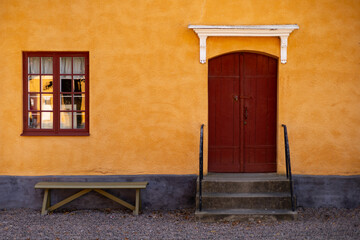 Yellow house wall with brown door