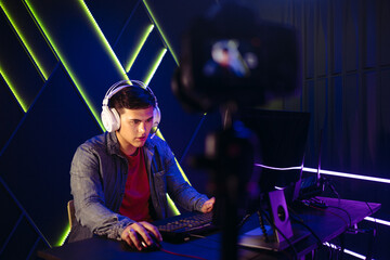 Fototapeta na wymiar Male gaming influencer live streaming himself playing a video game