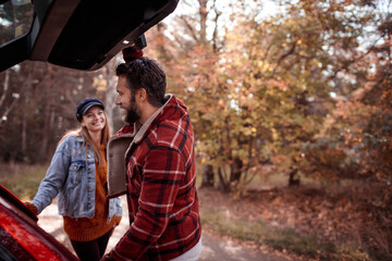 Young Caucasian couple getting ready to go on a hike in a forest park