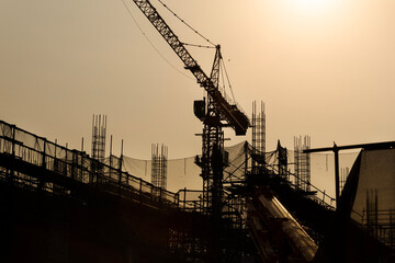Silhouette of crane and building construction site.