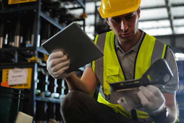 Caucasian male engineer holding tablet with car spare parts to check quality of workpieces in...