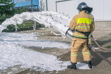Firefighters in protective clothing with the help of foam generators supply foam to extinguish the...