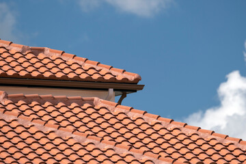Overlapping rows of yellow ceramic roofing tiles covering residential building roof in southern Florida - obrazy, fototapety, plakaty