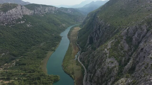 Old towns of Croatia. Summer holidays. Yachting. Cetina River winding its way through Rugged mountains gorge into adriatic sea in Omis Town. Aerial. Morning