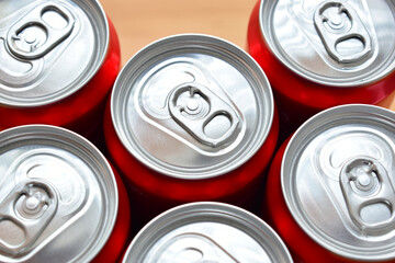 close up group of aluminium red cans soft drink put on brown wooden table