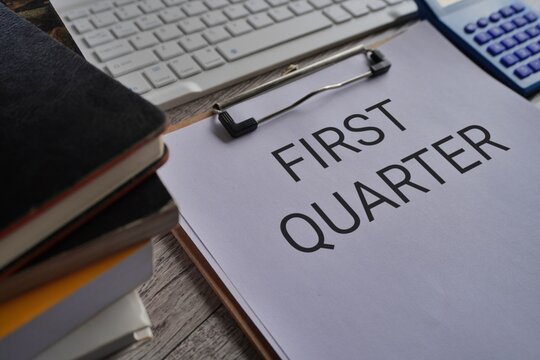 Close up image of paper clipboard with text FIRST QUARTER on office desk