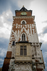 Fototapeta na wymiar Premises of the town hall with clock in the old town in the center of Krakow against the background of a cloudy sky