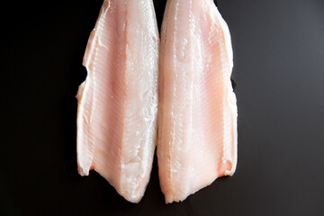 Whitefish fillets on the black background. Top view.
