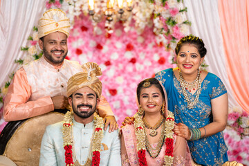 Portrait of Happy smiling Indian middle aged Father and Mother with newly wed daughter and son in...