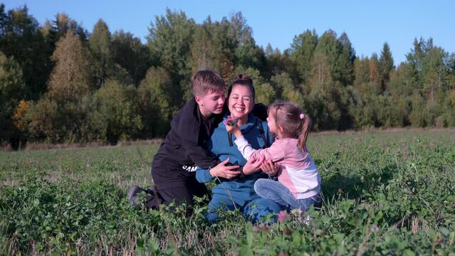 Mother, son and daughter in a happy embrace, outdoors