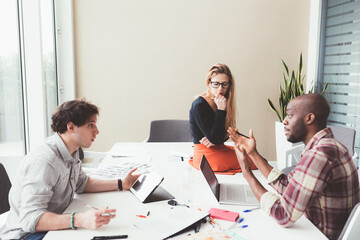 three colleagues working together in modern office with computer