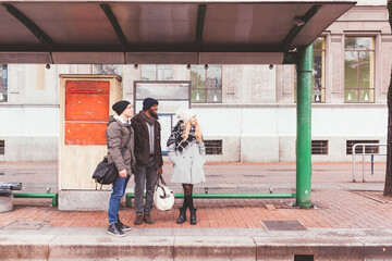 three friends waiting taxi outdoor