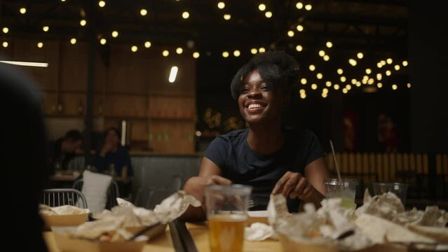 Portrait Of Pretty African American Woman At Table In Restaurant During Party And Friends Meeting