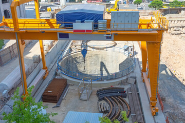 Metal crane for installing a frame into an excavated subway tunnel.