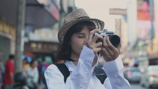 Tourism concept of 4k Resolution. Asian woman taking pictures of city attractions with excitement.