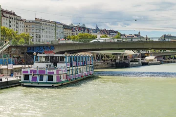 Foto op Plexiglas Vienna, Austria. Sightseeing tour boat on a canal of the Danube River under the Sweden Bridge. Mooring near Wolfgang-Schmitz-Promenade. 2023-08-02. © Alessandro