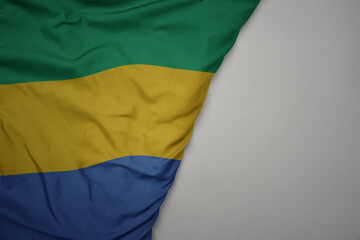 big waving national colorful flag of gabon on the gray background.