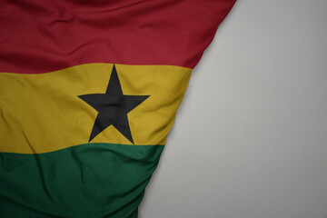 big waving national colorful flag of ghana on the gray background.