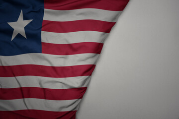 Obraz premium big waving national colorful flag of liberia on the gray background.