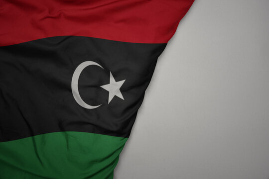 big waving national colorful flag of libya on the gray background.