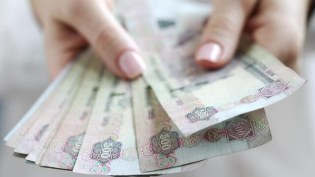 Woman Counting AED Dirhams in hands, closeup