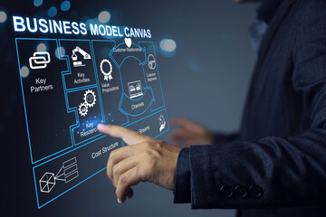Businessman working on business model canvas virtual screen chart to planning activity partner customer segment costructure and evaluate asset before investment. Startup business planning concept.