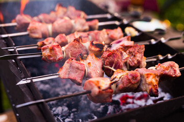 Cooking, barbecue and food concept close up of shish kebab meat on skewers roasting on brazier grill