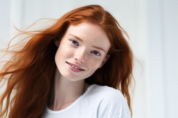 Portrait of beautiful young red hair woman with freckles smiling and looking at camera, standing on white isolated white background