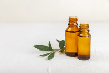 Olive essential oil. Glass bottle with olive oil on a texture table. Olive cosmetic oil. Serum for moisturizing and nourishing skin and hair. Beauty concept. Natural cosmetic. Copy space.spa