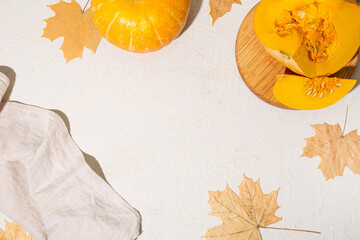 Yellow autumn leaves and pumpkins on a white background, autumn light background with free space for text