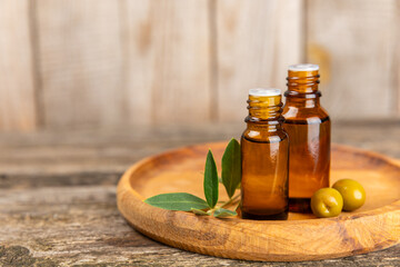 Olive essential oil. Glass bottle with olive oil on a texture table. Olive cosmetic oil. Serum for moisturizing and nourishing skin and hair. Beauty concept. Natural cosmetic. Copy space.spa